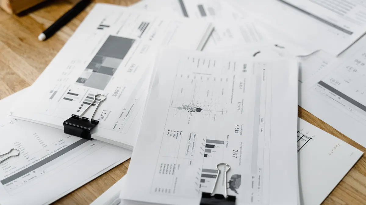 Uitgeprinte overzichten met cijfers en percentages op een houten bureau
